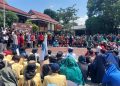 Mahasiswa bersama masyarakat Garut duduk bersila di depan Gedung DPRD saat aksi damai, Selasa (2/9/2025), sambil mencatat absensi para legislator yang hadir./Kabariku