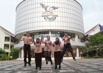 Sejumlah siswa berseragam pramuka berpose gembira di depan gedung SMA Unggulan M.H. Thamrin Jakarta (Foto: Instagram/@smanumht)