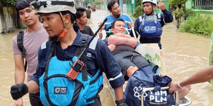 Potret aksi cepat Tim Yayasan Baitul Maal (YBM) PLN membantu evakuasi warga yang terdampak banjir di Medan