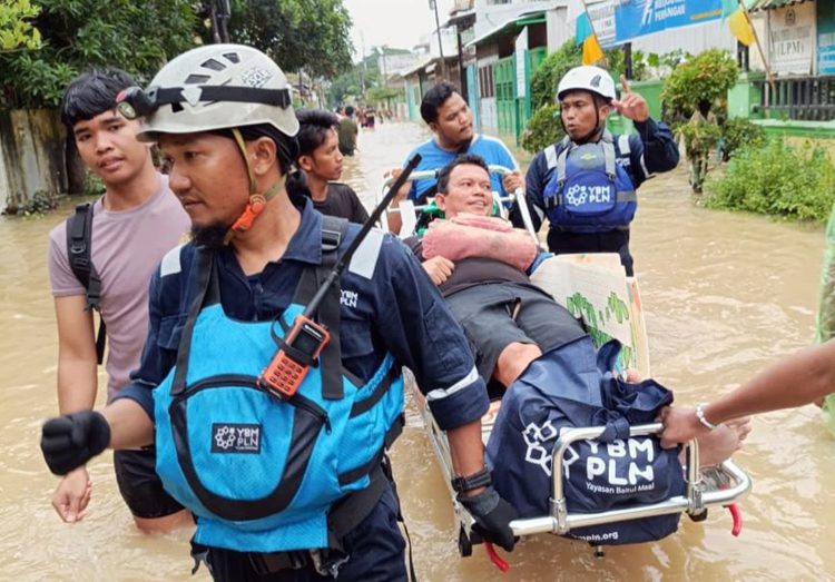 Potret aksi cepat Tim Yayasan Baitul Maal (YBM) PLN membantu evakuasi warga yang terdampak banjir di Medan