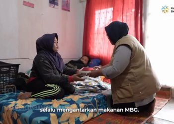 Nurbaeti menyerahkan paket MBG kepada penerima manfaat/IST