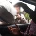 Foto: Tangkapan layar video viral, seorang perempuan menyerahkan uang yang dibungkus karung ke dalam mobil.