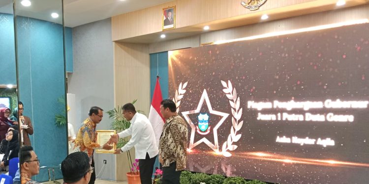 Gubernur Jawa Barat Erwan Setiawan menyerahkan penghargaan kepada Kepala DPPKBPPPA Garut Yayan Waryana/IST